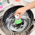 Wukusy cleaning brush with soap dispenser scrubbing a black frying pan in the kitchen sink