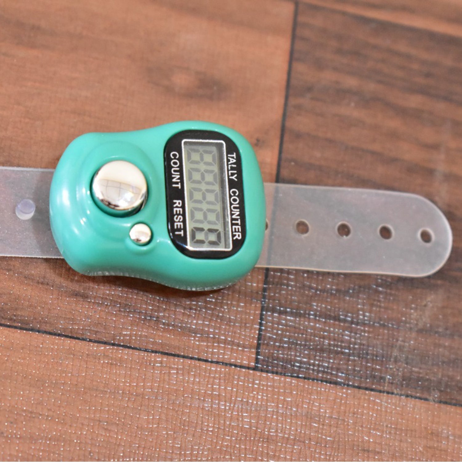 Wukusy digital finger tally counter with green body and transparent adjustable strap on wooden surface