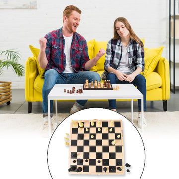 Wukusy folding wooden chess board in use by two adults playing chess on white table indoors