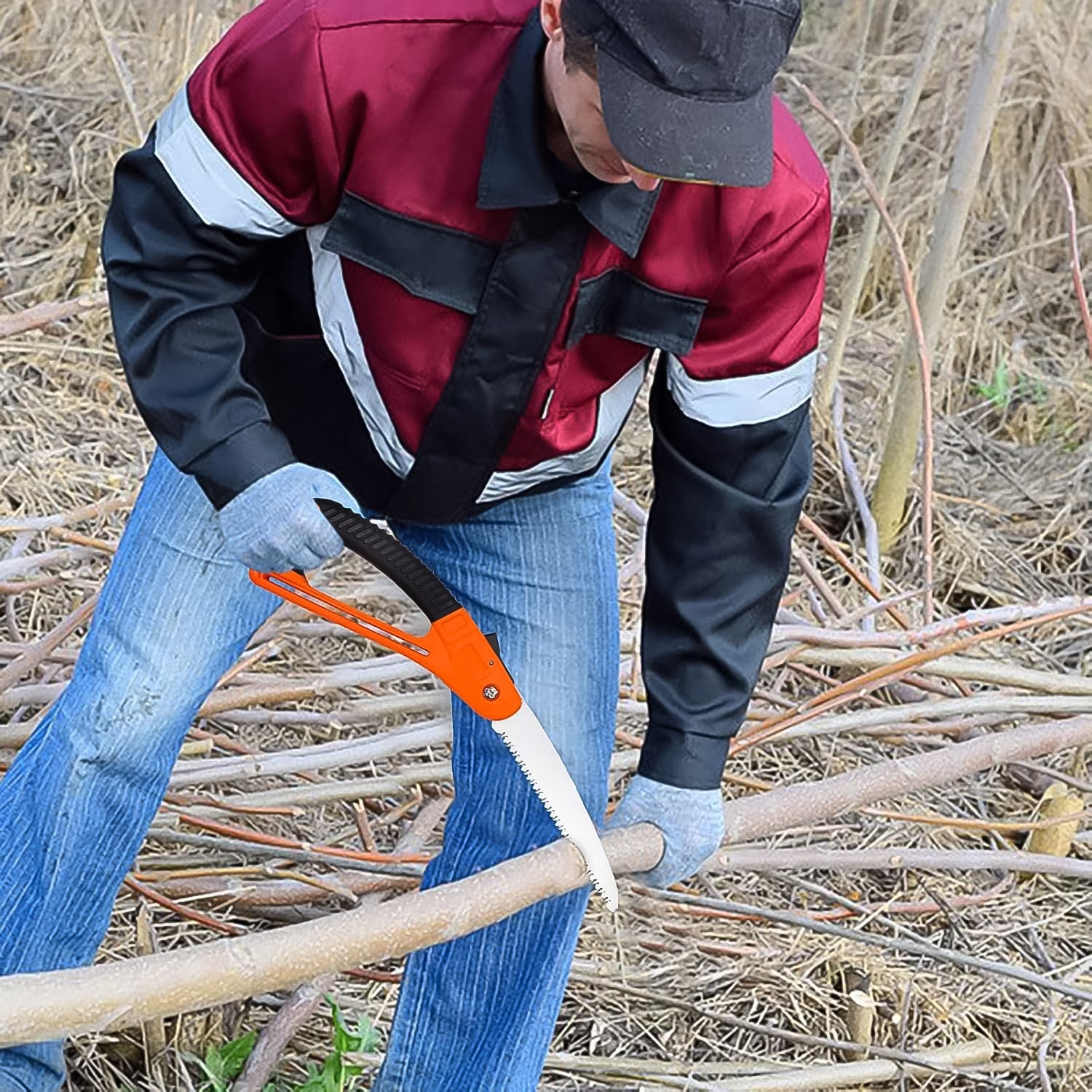 Person using Wukusy mini folding pruning saw with orange handle to cut branches in garden