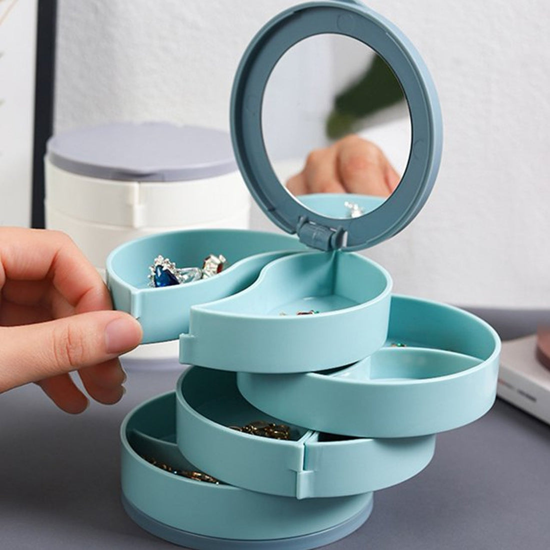 Wukusy portable jewelry organizer with mirror in blue holding various earrings and rings