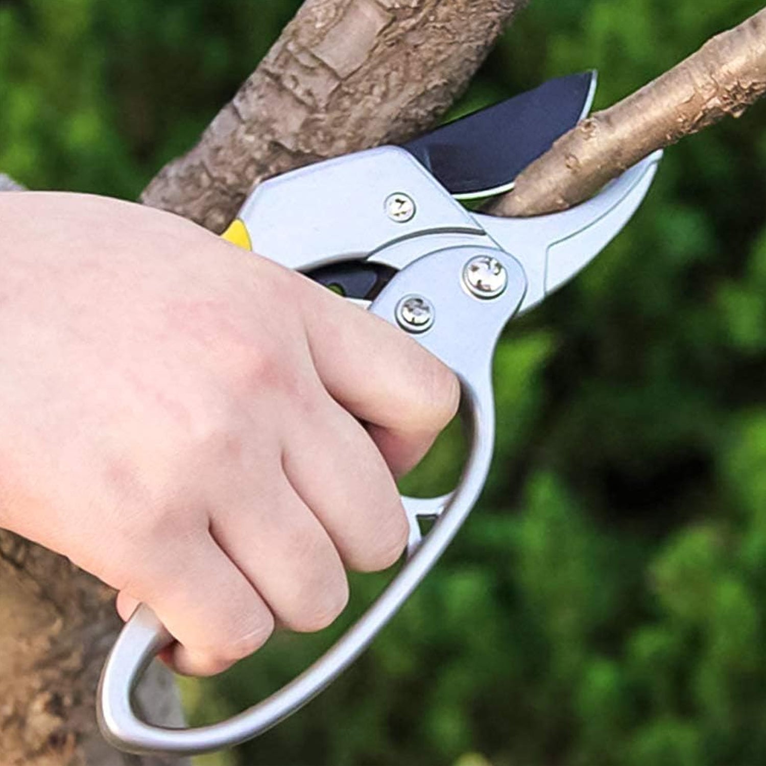 Wukusy professional gardening shears cutting a tree branch with ergonomic handle in garden