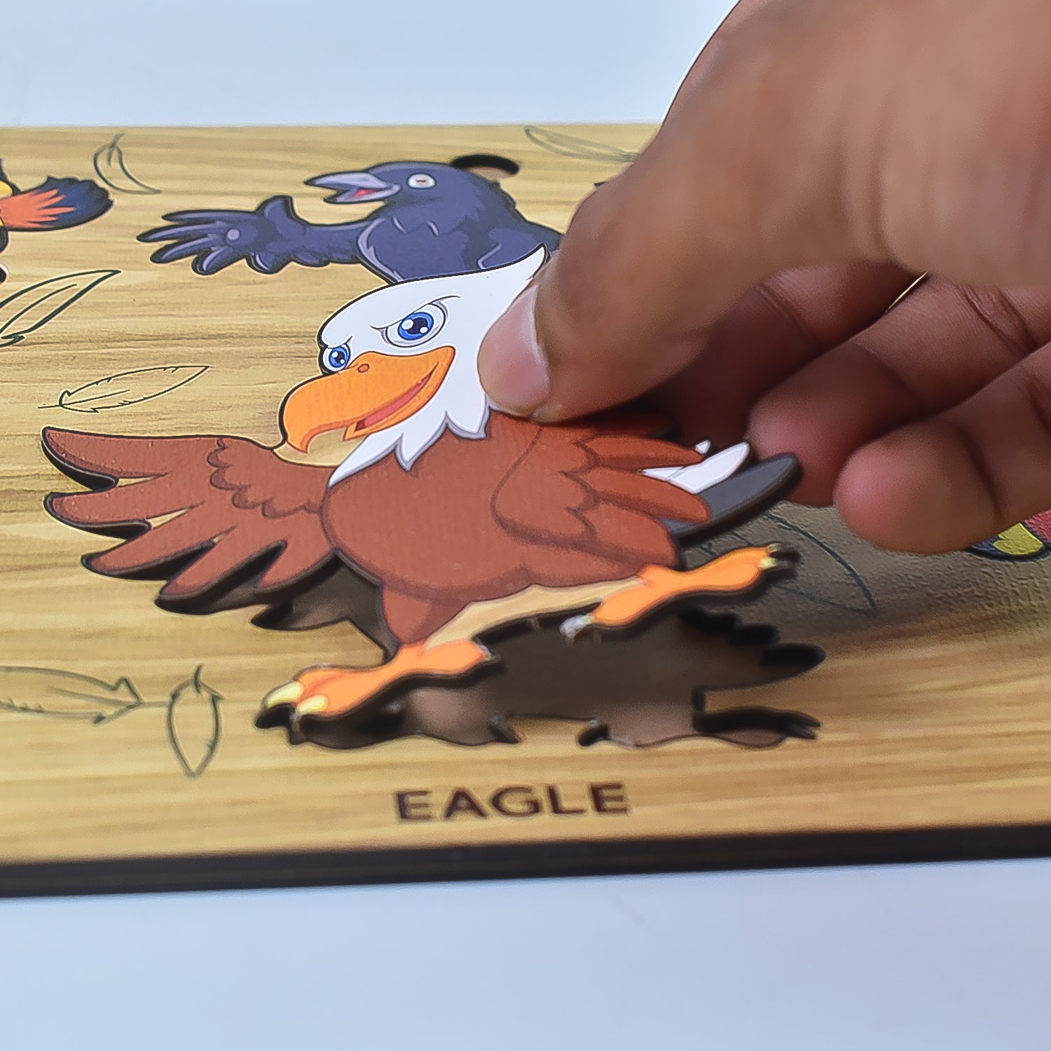 Wukusy wooden bird puzzle for kids featuring an eagle piece being placed by hand on a wooden board