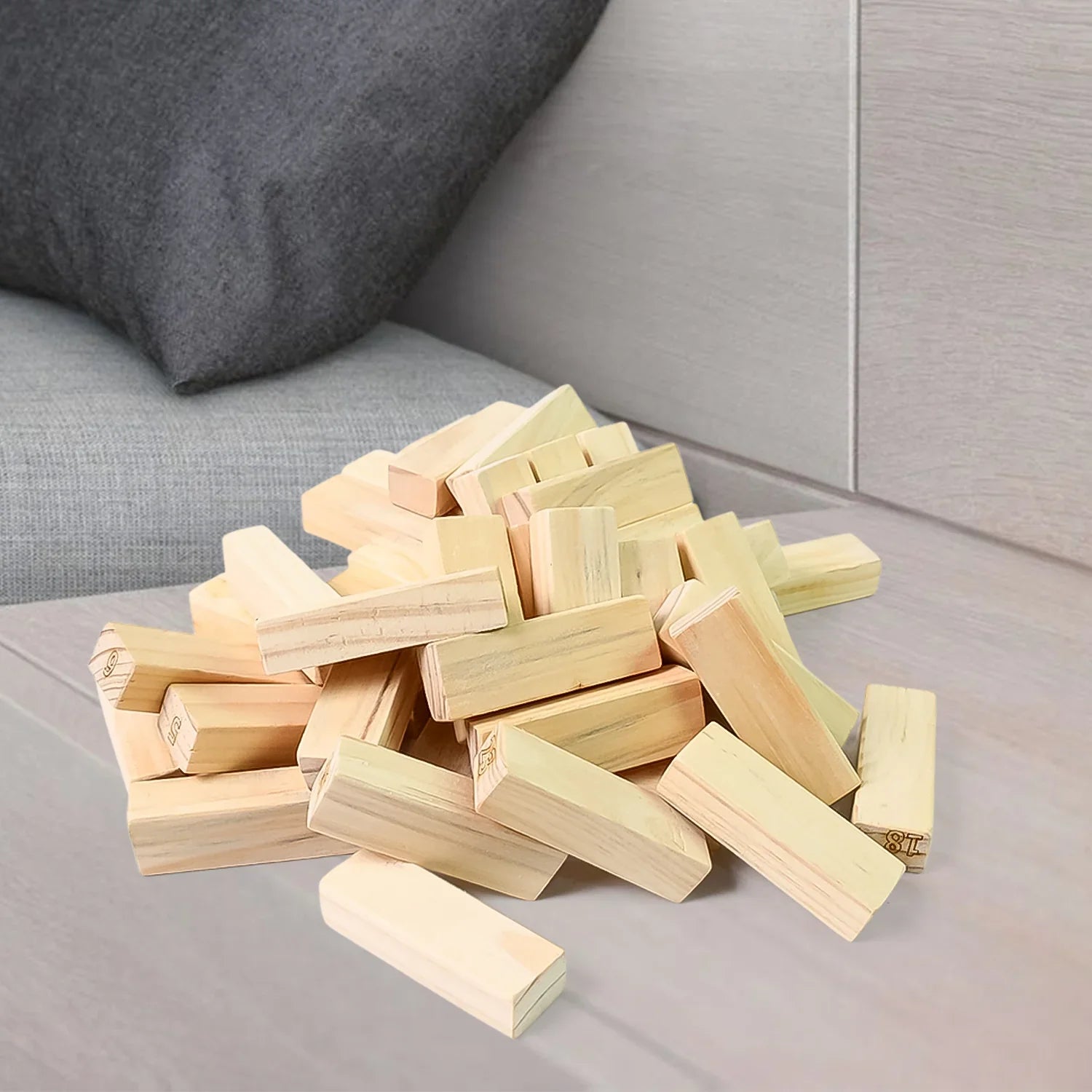 Wooden Stacking Tower Game Classic Blocks - Market FindsMarket Findswooden stacking tower game pieces scattered on a light wood table near gray couch